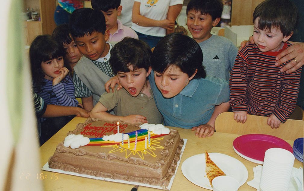 blowing candles on child bday cake