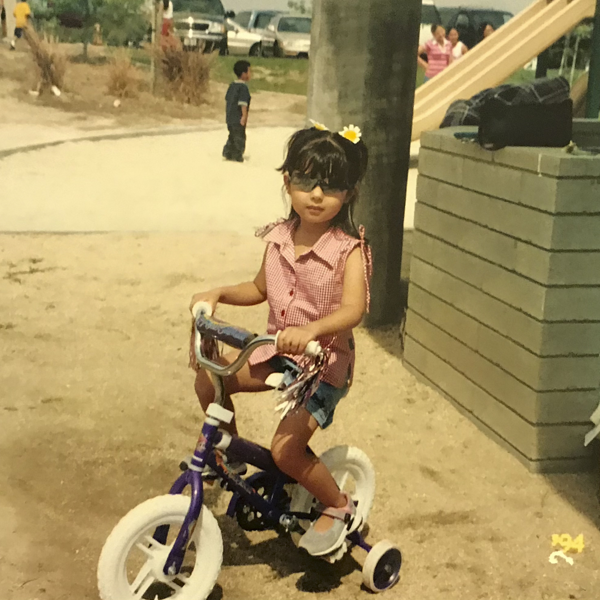 Kim riding a tricycle