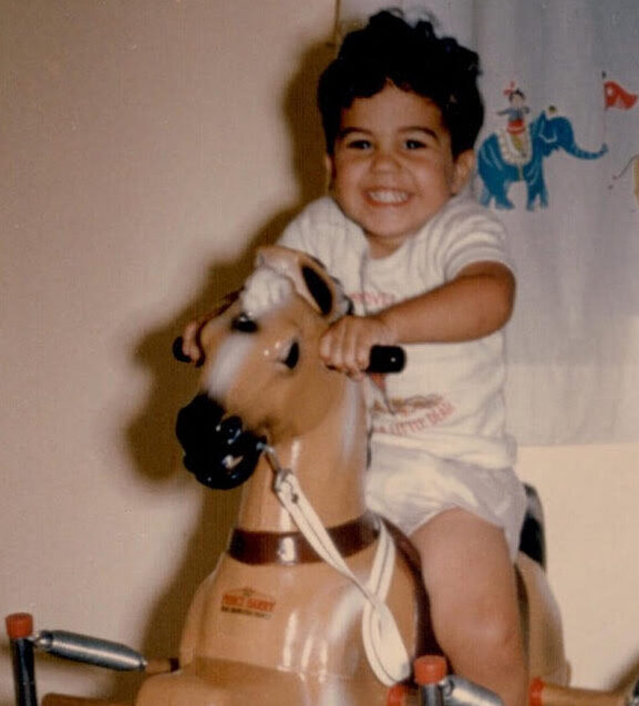 Young boy riding a play horse